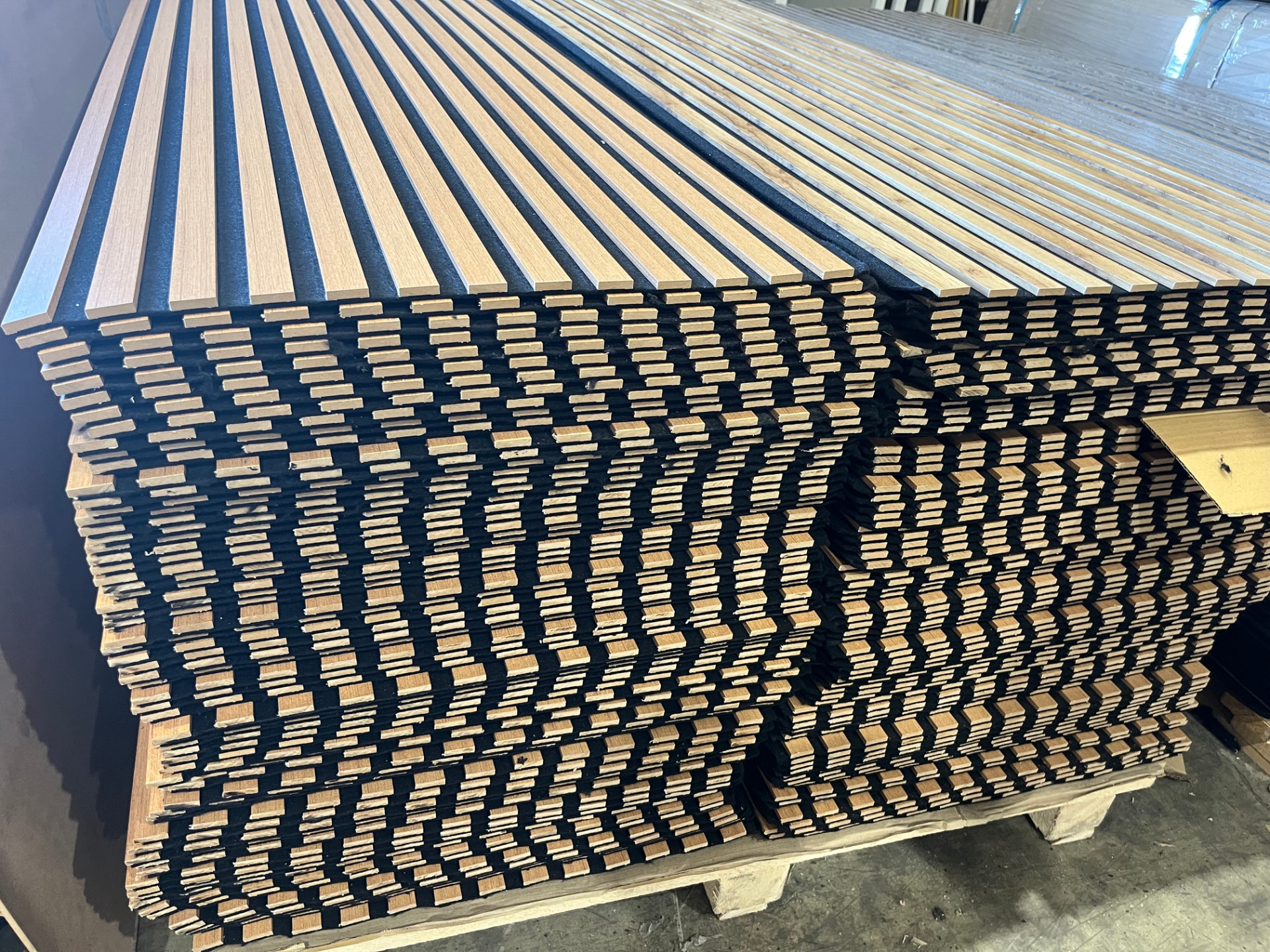 Stacked oak acoustic wall panels on a wooden export pallet